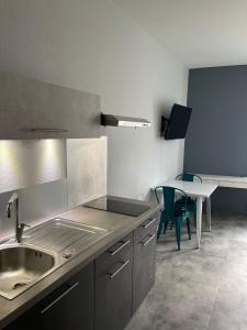 a kitchen with a sink and a table at Rooftop d'exception au Cœur du Puy-en-Velay in Le Puy en Velay +3 photos
