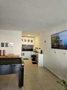 a room with a pool table and a flat screen tv at Surf'O Hostel in Rio de Janeiro