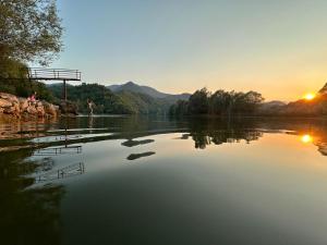 a view of a river with the sunset in the background at Skadar Lake Family Resort in Rijeka Crnojevića