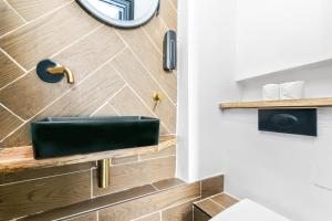 a bathroom with a black sink on a wooden wall at G Eighty Four in London +144 photos