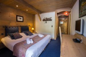a bedroom with two beds and a flat screen tv at Chalet Hotel L’Ecrin in Tignes