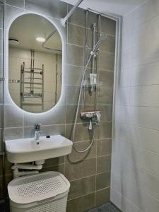 ein Badezimmer mit Toilette, Waschbecken und Spiegel in der Unterkunft 1BR Demure Design Urban Living Space in Helsinki