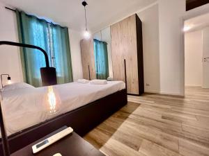 1 dormitorio con cama y mesa con mando a distancia en Kibilù - Via Valtellina - Quartiere Isola - Stazione Garibaldi - Monumentale - vicinanze Brera, en Milán
