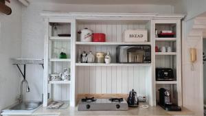 un armario de cocina lleno de muchos artículos de cocina en Villa Bel Fiori Apartment - 4 Sleeper, en Ballito