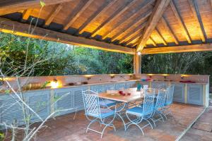 een terras met een tafel en stoelen onder een pergola bij Villa Federica 17 in Manciano