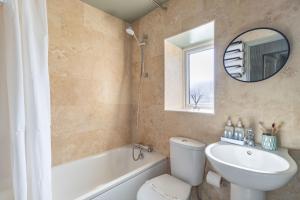 une salle de bain avec toilettes, lavabo et miroir dans l'établissement Hermitage Cottage, à Gloucestershire