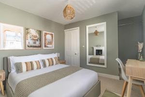 une chambre avec un lit, une table et un miroir dans l'établissement Hermitage Cottage, à Gloucestershire