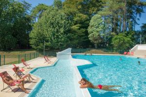 a group of people swimming in a swimming pool at VTF Le Domaine de Françon in Biarritz