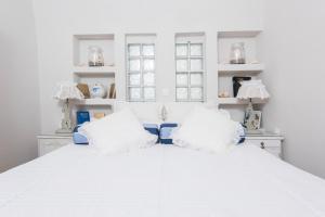 a bedroom with a white bed with two pillows at Iokasti Villa in Fira