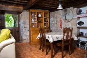 a kitchen with a table and chairs and a stone wall at Casa Jacinta in Bimenes