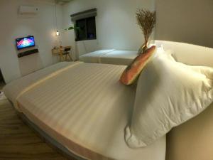 un grande letto bianco in una camera con TV di Anvien Motel a Phu Quoc Altre 2 foto