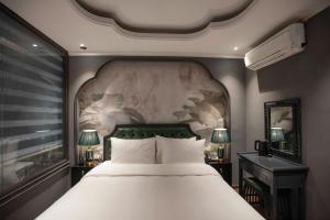 a bedroom with a large bed and two lamps at Madelise Stardust Hotel & Travel in Hanoi