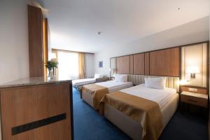 a hotel room with two beds and a television at Legends Hotel in Sofia