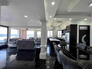 a living room with couches and a table and windows at Villa Monterrico in La Muerte