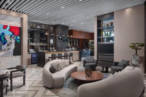 a lobby with a bar with couches and chairs at Four Points by Sheraton Izmir in İzmir