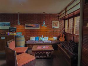 门多萨OlasHostel的带沙发和吉他的客厅
