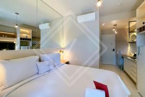 a bedroom with a large white bed and a mirror at Zainalofts7 Perdizes- Ao lado Allianz Parque 212 in Sao Paulo +5 photos