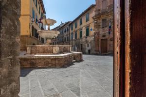 una calle vacía con una fuente en un callejón en la danza delle farfalle, en Siena