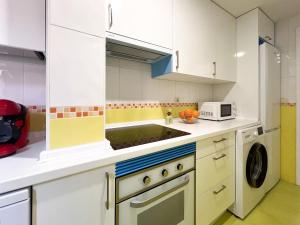 a kitchen with white cabinets and a stove top oven at FuensalidaHomes 206 in Fuensalida