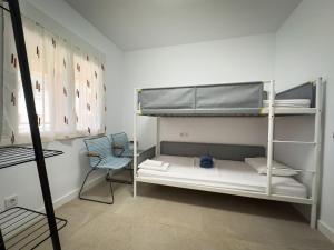 a room with two bunk beds and a chair at Beachfront Apartment Primera Línea 2-04 in Orihuela Costa +28 photos