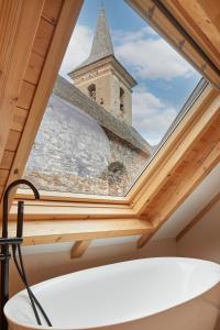 un lucernario sul tetto di un edificio con una chiesa di Era Artiga by FeelFree Rentals a Les Bordes Altre 27 foto