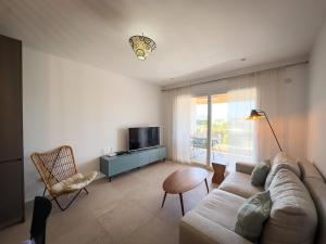 a living room with a couch and a television at Beachfront Apartment Primera Línea 2-04 in Orihuela Costa
