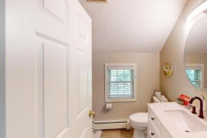 a white bathroom with a toilet and a sink at Lou n' Lil's in Glen Arbor +24 photos