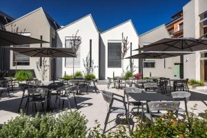 an outdoor patio with tables and chairs and umbrellas at RH Lifestyle Rooms & Suites in Olbia