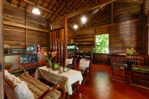 a dining room with a table and chairs and wooden walls at Xóm Sình Homestay & Farmstay Buôn Ma Thuột ĐakLak in Ðat Lý (1)