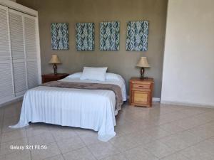 a bedroom with a bed and two night stands with lamps at Delfin in Cruz de Huanacaxtle
