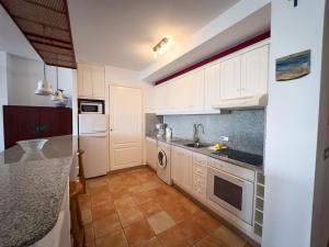 a kitchen with white cabinets and a counter top at Beachfront Apartment Primera Línea 2-06 in Orihuela
