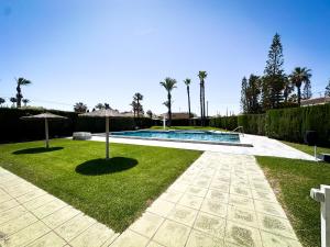 a backyard with a swimming pool and a lawn at Beachfront Apartment Primera Línea 2-06 in Orihuela