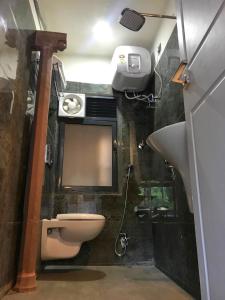 a bathroom with a toilet and a sink and a mirror at VIA VARANASI-A Boutique Hotel in Varanasi
