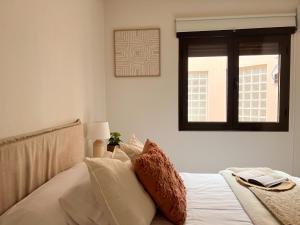 a bedroom with a bed with white sheets and a window at FuensalidaHomes 207 in Fuensalida