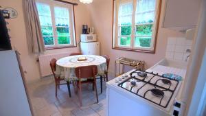 a kitchen with a table and a stove top oven at Une pause À la campagne in Oches