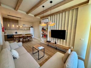 a living room with a couch and a tv and a kitchen at Aquaterra, Green Coast in Palasë