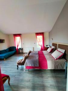 ein großes Schlafzimmer mit einem großen Bett und einem Sofa in der Unterkunft Chambre d'Hôtes du Bois Joli in Mesnard-la-Barotière