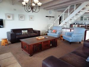 a living room with a couch and a coffee table at Whale Watch Cottage in St Helena Bay