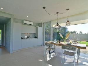 a kitchen and dining room with a table and chairs at VILLA MANDORLO 4, Emma Villas in Ragusa