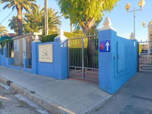une clôture bleue avec un portail avec un panneau dessus dans l'établissement La terracita de Dénia, à Dénia