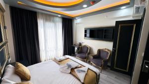 a hotel room with a bed and two chairs at DNZ TAXIM FERİDİYE HoTEL in Istanbul +37 photos