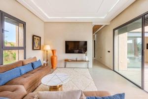 un salon avec un canapé et une télévision dans l'établissement villa Zina, Élégance et luxe,piscine & jacuzzi, à Marrakech
