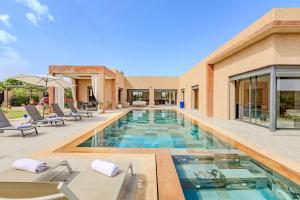 une piscine au milieu d'une maison dans l'établissement villa Zina, Élégance et luxe,piscine & jacuzzi, à Marrakech