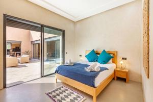 une chambre avec un lit avec des oreillers bleus dans l'établissement villa Zina, Élégance et luxe,piscine & jacuzzi, à Marrakech 25 autres photos