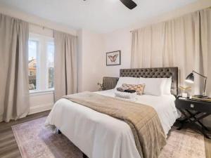 a bedroom with a large white bed with a desk at Newly Renovated - Professionally Designed - 2 BR in Lakewood