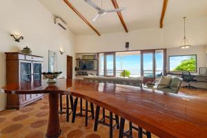 Una gran sala de estar con una gran mesa de madera. en La Perla del Caribe - Villa Emerald, en San Pedro