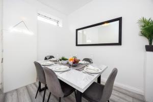a dining room with a table with chairs and a mirror at Quick Access to London City, Self Check-in! in London