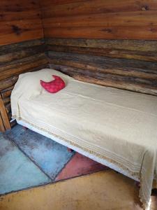 a small bed with a red pillow on it at Habitaciones individuales en La Llave in San Javier