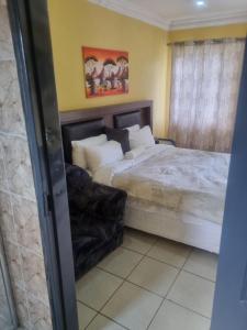 a bedroom with a large bed and a shower at Jazreel b&b in Vanderbijlpark