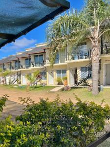 a building with a palm tree in front of it at Brisas del Lago Apartamentos in Colón